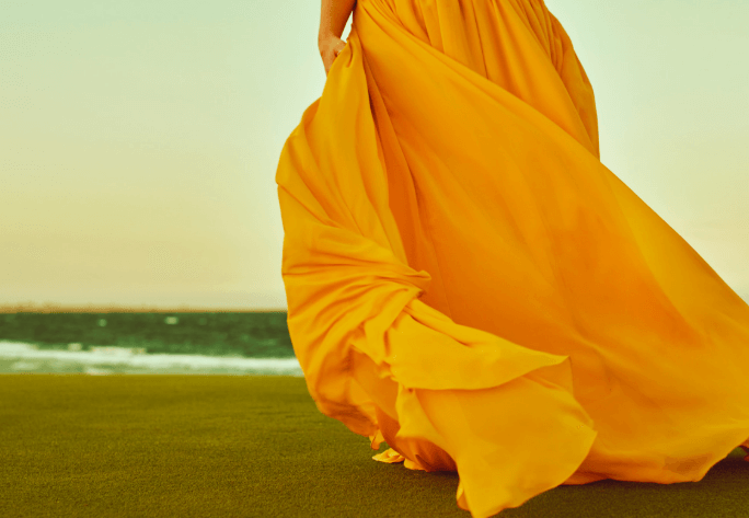 Dress Shades That Complement Your Natural Features 1 woman in yellow dress standing on grass highlighting color choice